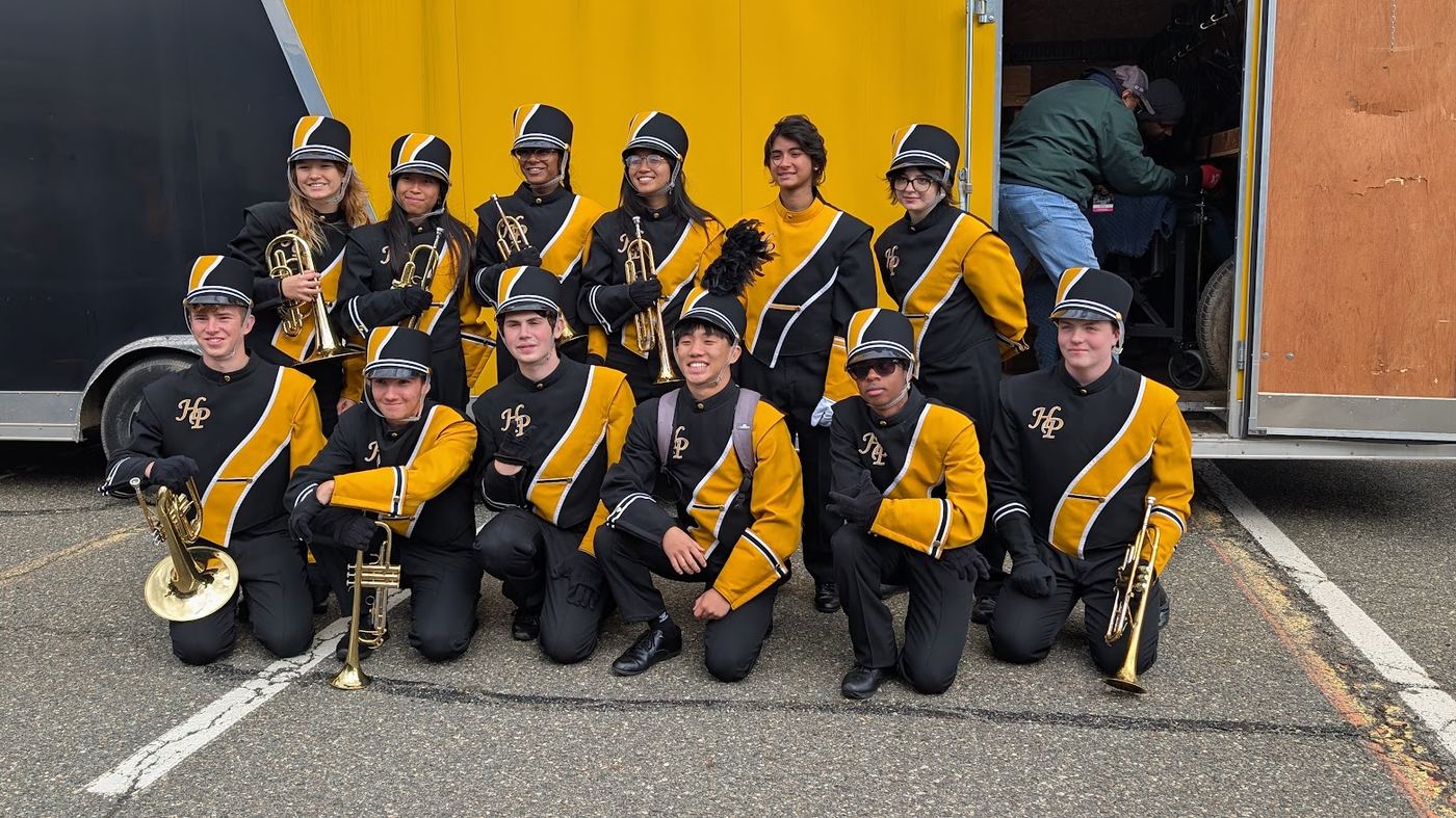 Brass players posing together beside the equipment trailer
